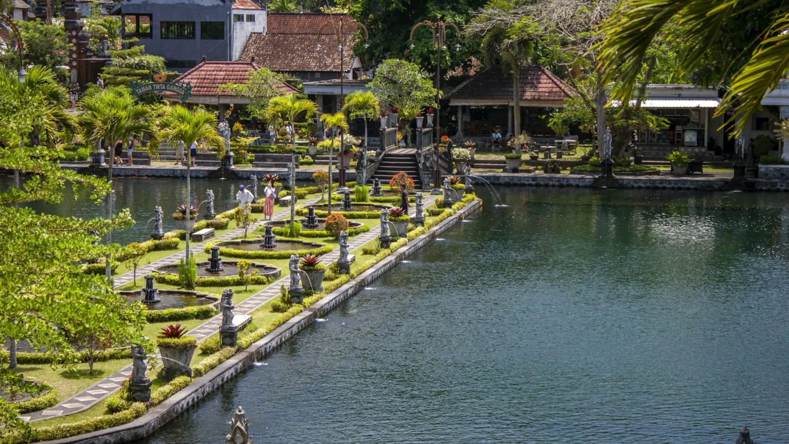 Tirta Gangga water palace in East Bali with its long pool, stone statues and gardens