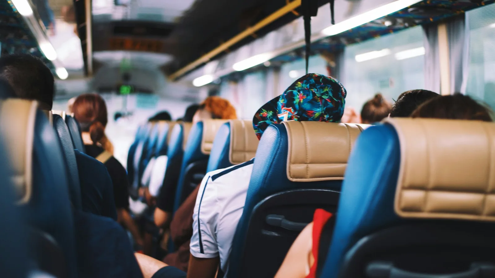 Passengers seated in rows inside a crowded group tour coach